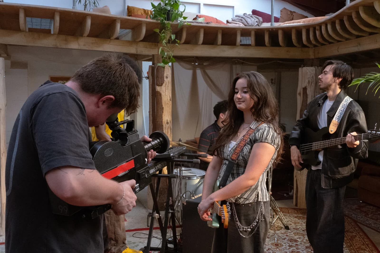 A camera operator filming Clarissa Mae and her band with a 16mm film camera at Bean World Studios